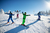 Family having fun skiing together on winter day