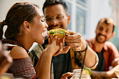 Happy couple sharing a tacos in a restaurant..
