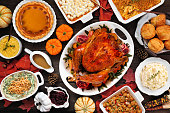 Traditional Thanksgiving turkey dinner table scene on a rustic dark wood background