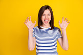 Photo portrait of funky young lady fooling show fingers claws growl tiger wear stylish striped garment isolated on yellow color background