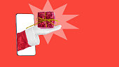 Santa claus hand showing a gift box on his palm with colored background