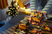 A woman is holding a DIY Gingerbread house