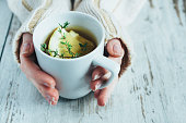 Cup of tea with thyme herb and lemon slices