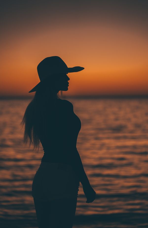 Silhouette of a Woman After Sunset by the Sea Free Photo